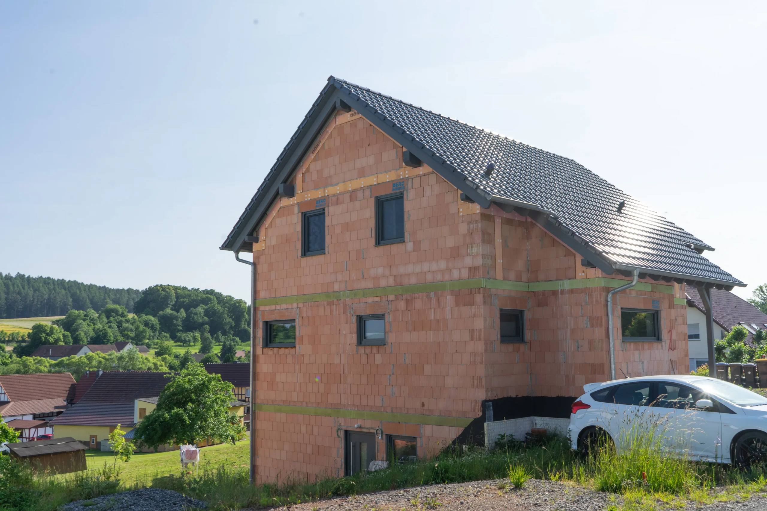 Rohbau eines Einfamilienhauses vor blauem Himmel.